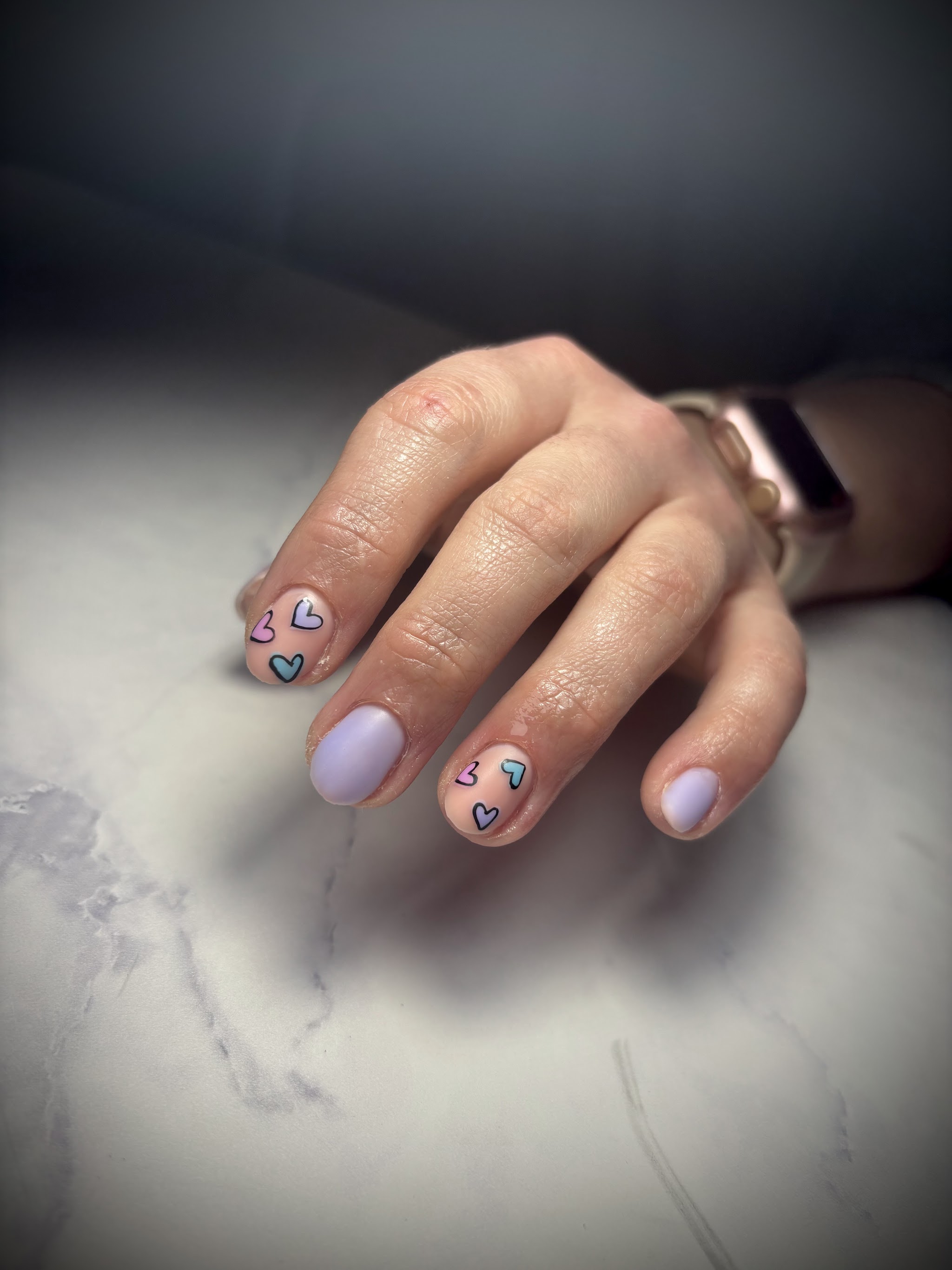 Lila nagels met pastelkleurige hartjes